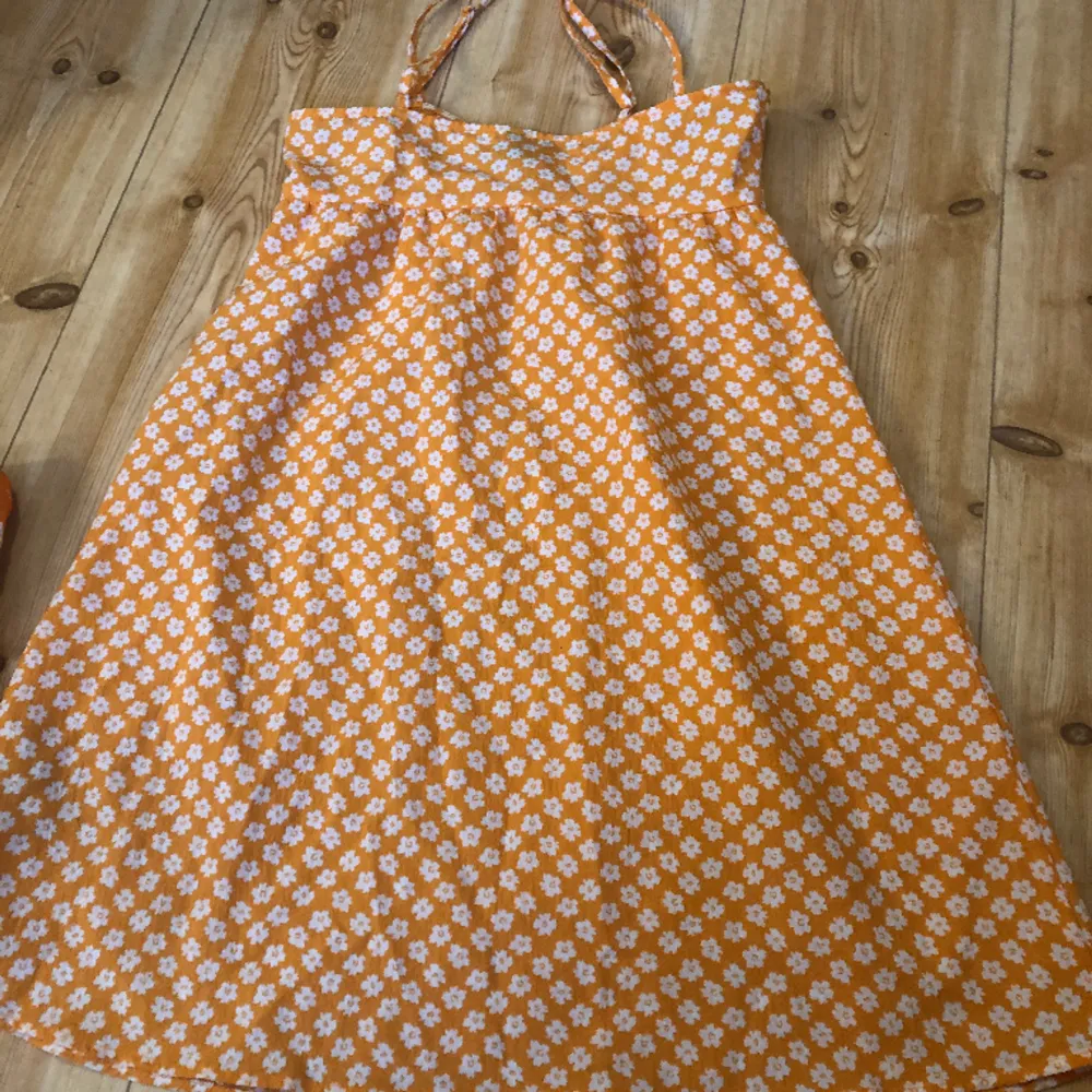 Fin orange klänning från H&m skulle säga att den är ganska kort och är i nytt skick är i strl 32 och säljer för 50:-. Klänningar.