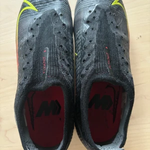 Fotbollsskor Nike Mercurial Vapor 14 Elite AG PRO Black x Prism - Svart Gul Röd storlek 39 - Köpt för små använda 20-tal gånger. Mycket bra skick. Storlek 39. Skosnören till finns. Nypris ca 2800kr.  Dessa lätta fotbollskor har prestanda Flyknit-material på vristen, vilket ger ökad flexibilitet och en perfekt passform.