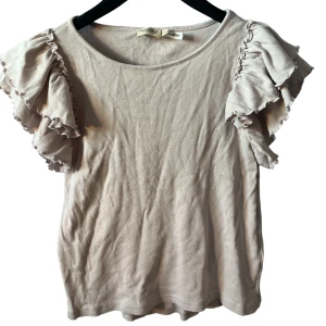 Lila volang t-shirt  - Jättefin t-shirt med volangärm i bra sick! Den är ljuslila med små blom inristning i tyget. 💕💕