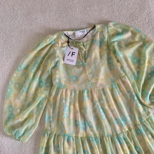 Selected Femme maxi floral dress - Otroligt vacker klänning från Selected Femme med färgglada blommor och vida ballongärmar. Knyts med liten rosett vid halsen. Ny med tags kvar, utan anmärkningar. Ordinariepris 999kr. Storlek XS men passar även S utan problem.