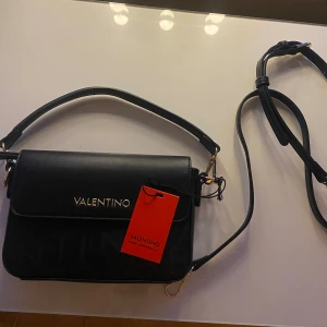 Valentino väska  - Säljer denna supersnygga och stilrena handväskan från märket ”valentino bags” då den tyvärr inte kommer till användning. Passar till alla outfits!! Ett kortare och ett längre axelband. Passar utmärkt till bal/studenten!! Köpt för 1 250kr på zalando