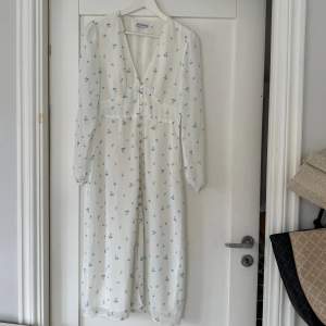 Säljer min vita klänning med blåa blommor på från Adoore i modellen Paris🩵den har några tråddragningar på framsidan🩵den är i storlek 36