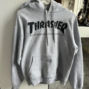 Grå THRASHER Huddie  - Säljer nu min snygga, sköna grå thrasher huddie.  Inköpt från junkyard för 1249:-  Andvänd några få gånger💗 Jag är 160 så den passar mig i både längd å armar,säljer då jag inte andvänder den längre💗 Köparen står för frakt 🩷