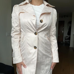 Rosa trenchcoat  - Fin rosa trenchcoat, köpt utomlands. Aldrig andvänd. Köpt för 475kr.