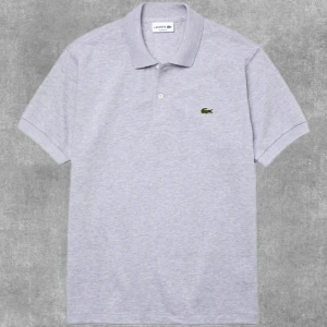Lacoste Pikétröja L1264 - Gråmelange  - Nyskick! Riktigt fin Lacoste Pikétröja L1264 - Gråmelange Använd max 5 gånger så är som ny fortfarande och nu när man blivit rundare runt magen så passar den inte längre på mig.