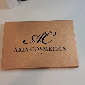 Ögonskuggspalett från Aria Cosmetics - En ögonskuggspalett från Aria Cosmetics med 20 olika färger. Paletten innehåller skimrande nyanser i färger som blå, grön, lila, rosa, guld, silver och brons. Förpackningen är i en elegant roséguldfärg. har bara swatchat den. oänvänd