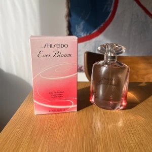Shiseido Ever Bloom Eau de Parfum - Shiseido Ever Bloom är en elegant och feminin Eau de Parfum med en harmonisk blandning av blommiga och träiga noter. Toppnoterna inkluderar bulgarisk ros, jasmin, lotus och viol, medan mellannoterna består av apelsinblomma och gardenia. Basnoterna är hinoki-trä och mysk. Parfymen kommer i en vacker genomskinlig flaska med en rosa nyans och en elegant förpackning. Bara testad några sprut.