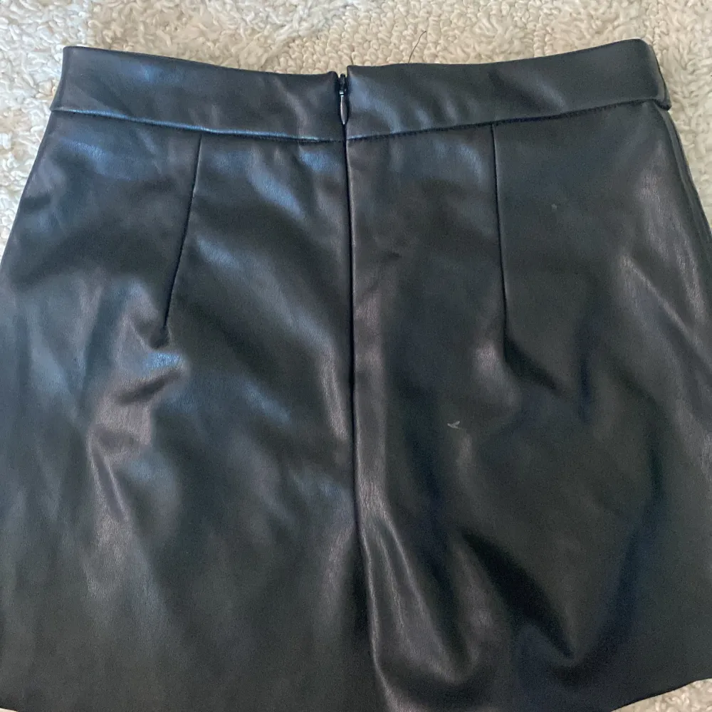 Säljer den här jättefina skinn kjolen som även är shorts,på framsidan ser det ut som en kjol och på baksidan är det shorts. De är i storlek 32 och är i mycket bra skick.. Kjolar.