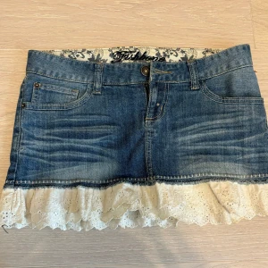 Fishbone kjol med spetsdetaljer - Säljer denna supersnygga jeanskjol med spetsdraperi från fishbone, den är i storlek s men skulle säga att den passar en xs också 