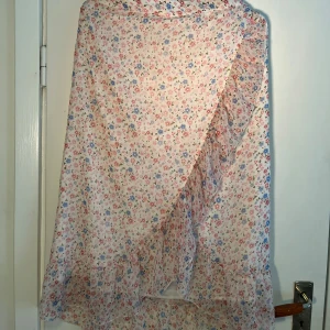Kjol - Blommig kjol ifrån vero Moda. Volanger med knytdetalj i midjan. Snöret på sidan har ruggats upp lite (se andra bilden).