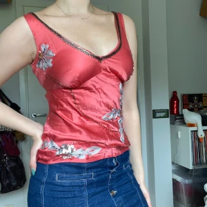 Silkestopp med broderier - Korallrosa silkestopp med broderier i silver och pärlor. Dekorativt band som knyts i ryggen. Storlek 34 men passar 36, perfekt skick!