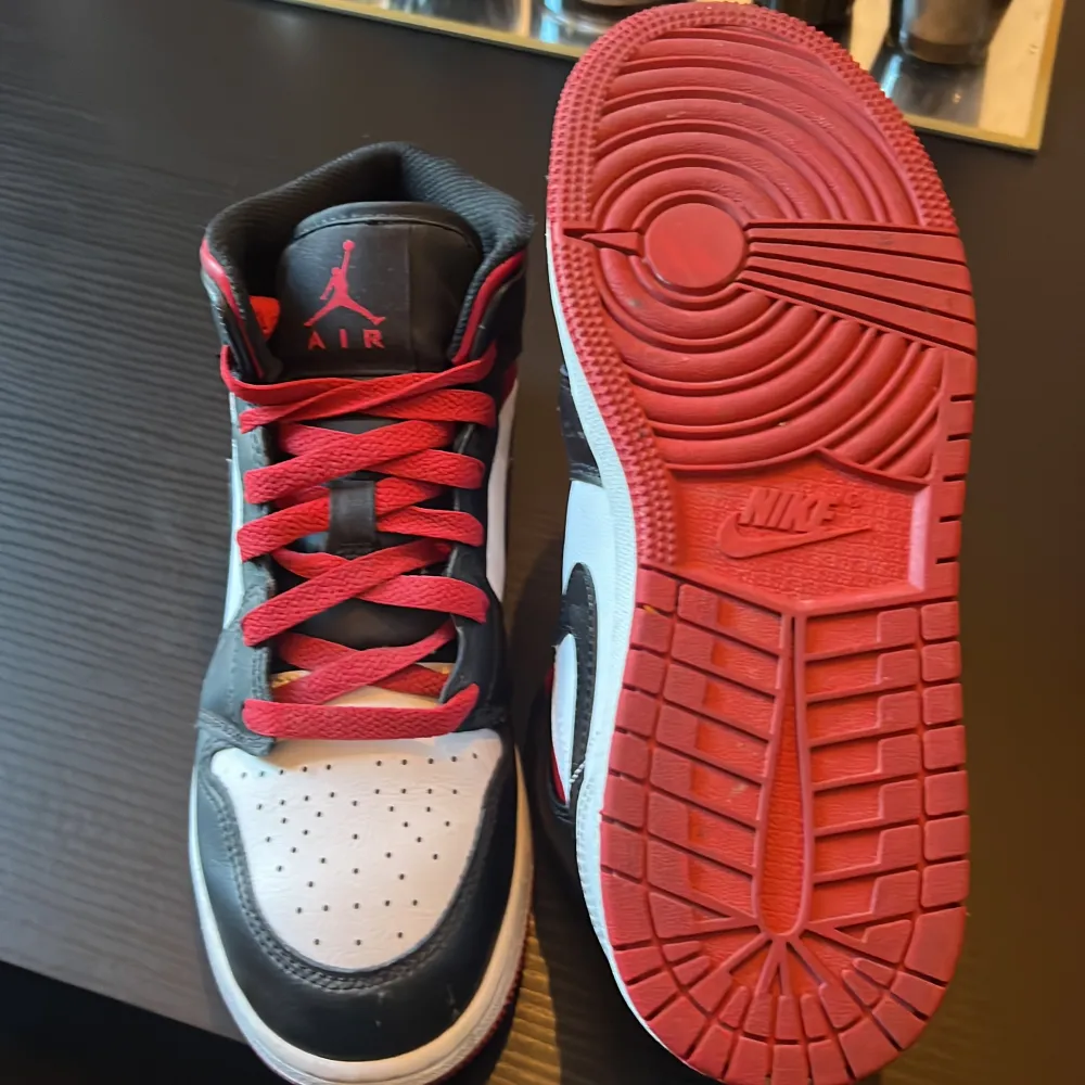 Fina Air Jordan 1 Mid Röd/Svart/Vit skor. 10/10 skick, använd 1 gång. Säljer eftersom den inte passar mig. Köpt nypris 1200kr från JD under September 2023 men säljer för 600kr.. Skor.