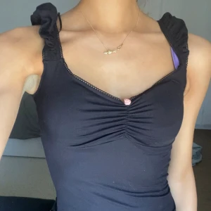 Svart top - Säljer denna jätte snygga toppen med en ros som detalj. Bra skick och även ny!