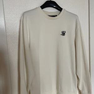 Siksilk tröja - Mycket fin tröja och sparsamt använd tröja från Siksilk. Säljes pga att den inte passar på mig längre och inte kommer till användning. Färgen är vit/cream. Hör gärna av dig vid eventuella frågor😄