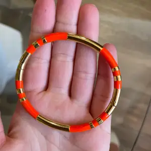 Guld/orange armband/cuff från By Malina. 