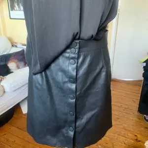 Svart medium längd skinn kjol från H&M i mycket fint skick
