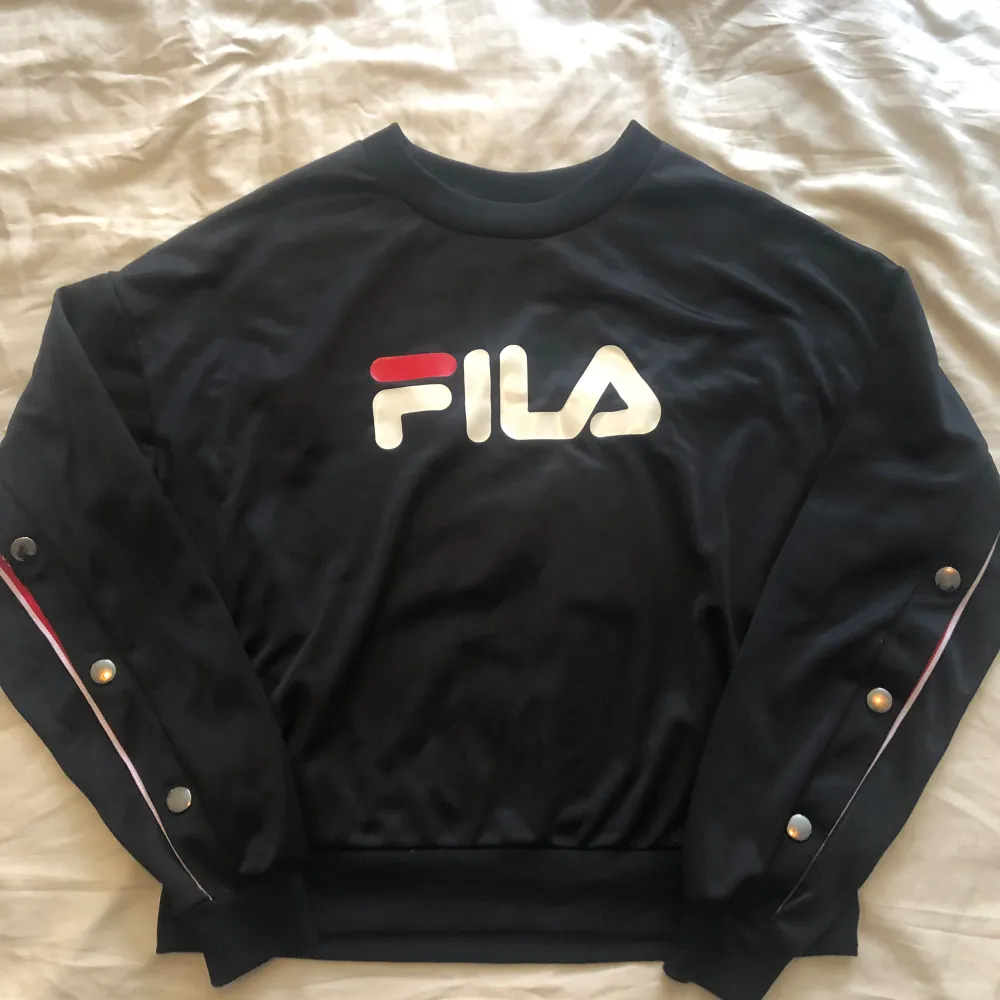 Svart med tryckknappar. Fina detaljer med rött och text Fila. Super snygg och knappt använd. Dottern skutta i längden så den är lite liten nu. Tröjan är i blankt material.  Denna långärmade Fila tröja mycket dyr i inköp.  Nypris 849:-  . Tröjor & Koftor.