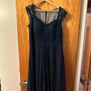 Balklänning  - Balklänning. Använd en dag som brudtärna. Mörkblå chiffong med spets. Dragkedja i ryggen. Bolero medföljer. Mkt fint skick. Garderob medföljer.