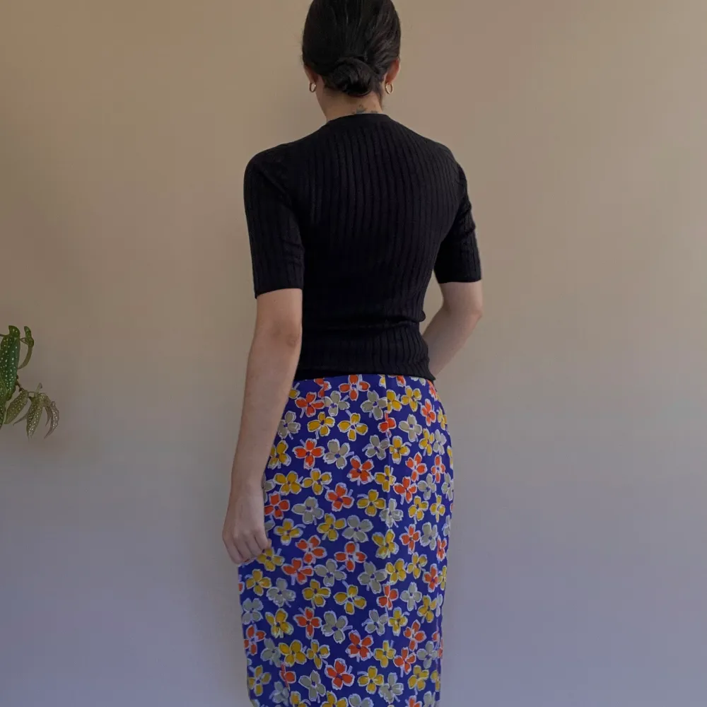 Vintage Purple Floral Printed Skirt w frontal pleating. Side Button and Zip Closure. Some color transfer in a white area, not visible when worn. Very Good Condition. Unlined. Best Fits M  Model is 160cm (5”3) and generally fits XS/S.  100% Silk. Kjolar.