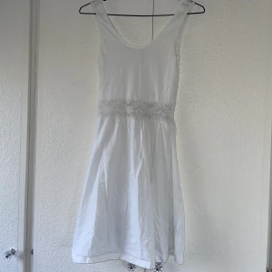 Vit klänning  - Vit klänning med spets över hela ryggen och runt midjan där fram Vet ej storlek men skulle säga att den passar S-M