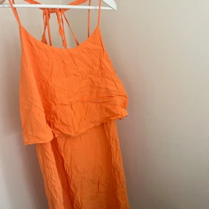 Orange klänning  - Knytning där bak, fin i ryggen. Storlek s 