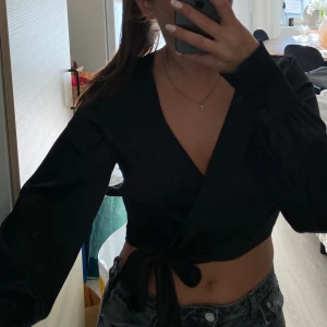 Svart blus - Jättefin omlott blus i svart från NA-KD 🖤 Osäker på storlek då jag verkar ha klippt bort den men skulle säga att den är som e S. Jättefint skick!