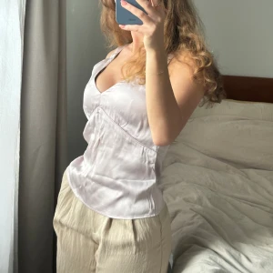 Pärlrosa/lila sidentopp från danska Gestuz - Använd 1 gång. Jättesnygg feminin topp i 100% viskos, skönt svalkande material för sommaren. Superfin kvalitet precis som allt från Gestuz. Har en liten sminkfläck på insidan som lätt går bort.