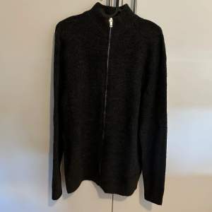 Helt ny full zip ull tröja som är i storlek M som är gjord i mycket fint material. Som är mörkgrå/svart.