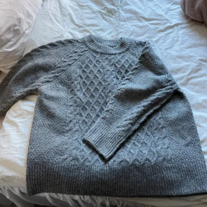Grå stickad tröja - Grå kabelstickad tröja från Lager157, sparsamt använd så den är i väldigt fint skick 🩶 Oversized på mig som är en XS.