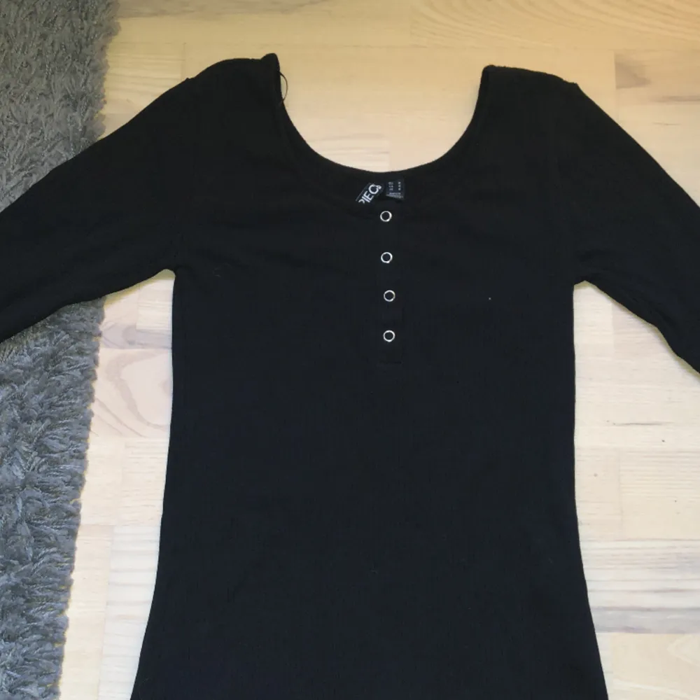 En långärmad svart tröja med knappar på. Den är i storlek M men är ganska liten, passar därför S också! Endast använd en gång. Pris kan diskuteras vid snabb affär! 🎱. T-shirts.