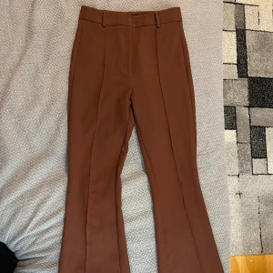 Kostymbyxor bruna - Bruna kostymbyxor. Storlek 38. Märke Dilvin från Chiquelle. Uppsydda för någon som är runt 165 cm lång. Knappt använda. Obs ganska liten medium.  200 kr 