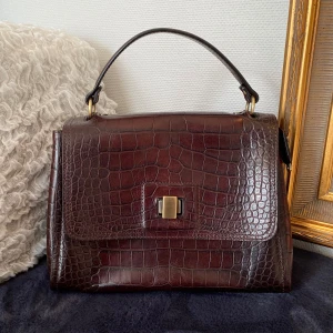 Italiensk väska i läder - Äkta läderväska från italienska Gianni Conti. Rödbrun i croco-mönster. Använd fåtal gånger. Inga defekter. Pris kan diskuteras. Hör av dig om du har frågor💓