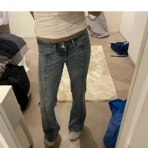 Lågmidjade bootcut jeans  - Coola o snygga blåa lågmidjade bootcut jeans med en sömm i mitten, samt två knappar som sitter asbra🤩✨😻 Pris kan diskuteras 