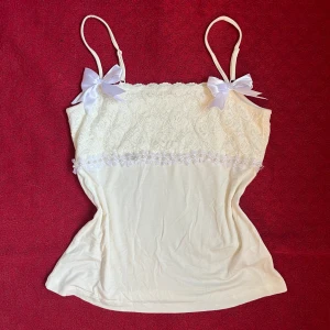 Vit topp med rosetter och pärlor - Denhär toppen är köpt vintage och vidare designad av mig. Den är i fint skick utan skador. Skriv privat om ni har frågor 🤍