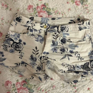 Blommiga shorts  - Vita shorts med fina blåa blommor på. Mycket bra skick