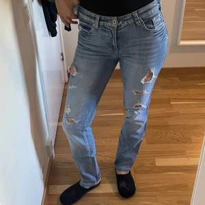 Blåa jeans med hål från Denim i storlek 38.