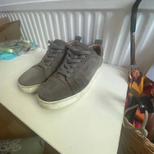 Louboutin utan spikar - Ett par gråa Louboutin utan spikar Storlek 42