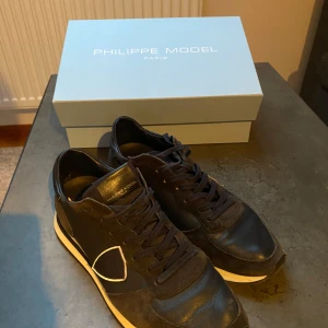 Svarta sneakers från Philippe Model - Snygga svarta sneakers från Philippe Model. Perfekta för en stilren look. Skorna kommer i originalkartong. Fräscht skick, ser lite mer använda ut på bild än vad dom är irl. Frågor så är de bara att skriva:) 