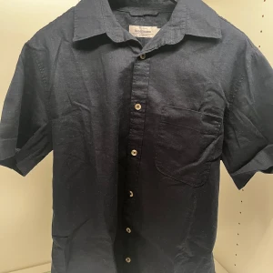 Linneskjorta Dressman - Snygg mörkblå kortärmad skjorta från Dressmann i linneblandning. Perfekt för varma dagar med en klassisk krage. Storlek S. Endast Swish betalning! Kontakta för fler frågor!