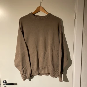 Beige tröja från Zara - Säljer en stilren beige tröja från Zara. Den har en klassisk rund hals och ribbade muddar vid ärmslut och nederkant. Perfekt för en avslappnad look. Helt ny och har aldrig används 