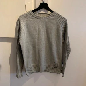 Unik grå stickad tröja - Unik grå stickad swestshirt | Sjukt snygg färg som passar till nästan allt | Storlek S passar | Nypris: 700kr vårat pris 199kr!✅ Kontakta vid mer frågor 👕Tröjan har en klassisk rund halsringning och långa ärmar.