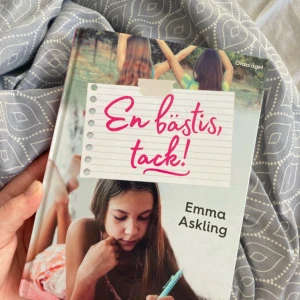 En bästis, tack! - Boken 'En bästis, tack!' av Emma Askling handlar om längtan efter en bästa vän. Den utforskar teman som vänskap och relationer, och är utgiven av Ordalaget. Omslaget visar en flicka som läser och två vänner som går tillsammans. Obs sidorna har blivit vikta som bokmärken men annars är den väsligt fint skick. Sidorna är intakta så inget problem med det.