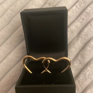Guldiga hjärtformade örhängen - Säljer ett par eleganta guldiga örhängen i form av hjärtan. Helt nya örhängen från Other stories aldrig använda❤️❤️