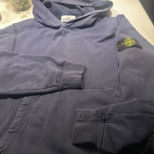 Blå hoodie från Stone Island Junior - Säljer en snygg blå hoodie från Stone Island Junior.  Hel och ren i gott begangnat skick. Inga fläckar. 