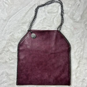 Vinröd väska med kedja  - Vinröd väska, 36x35cm. Defekter syns på bilderna. Vet ej om den är äkta därav priset. Köp sker via köp nu, jag postar inom 24h. Kvar tills markerad såld 