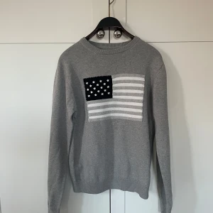 Grå tröja med flaggmotiv från GANT - Säljer en riktigt snygg grå tröja från GANT med ett flagg motiv. Väldigt bra skick👍hör av er om ni är intresserade. Pris kan diskuteras 