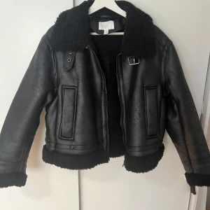 Skinnjacka från H&M - Svart jacka från H&M med pilefoder inuti. Jackan är i nyskick då den endast är testad. Storlek L men den är liten i storleken och passar mig som brukar ha S-M