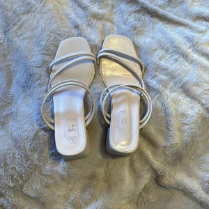 Beige sandaler med klack - Snygga beige sandaler med klack och flera tunna remmar. Perfekta för en stilren look med en fyrkantig tå och bekväm passform.