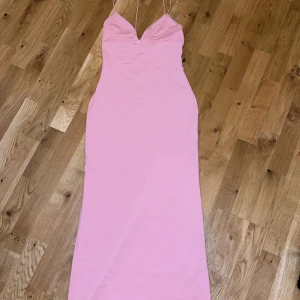 Rosa långklänning från Bershka - Säljer en söt rosa långklänning från Bershka med smala axelband och en liten rosett framtill. Perfekt för sommarens alla tillfällen. 💖i storlek M