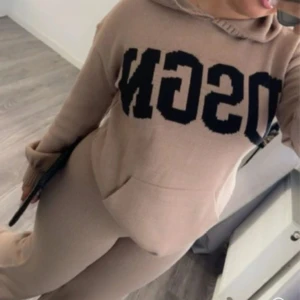 Beige hoodie set från dsgn - Säljer en mysig beige hoodie med stor svart text på framsidan. Tröjan har långa ärmar och en klassisk känguruficka framtill. Perfekt för en avslappnad stil. Hör av dig vid intresse! DET ÄR ETT SET! 